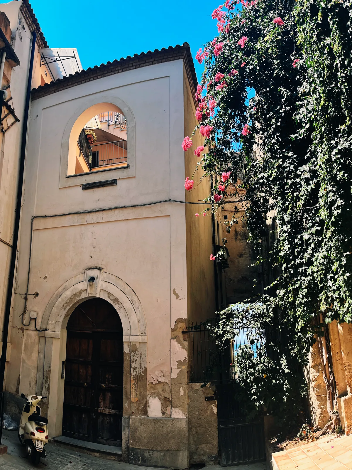 A Tropea building draped in flowering vines above the Tyrrhenian Sea